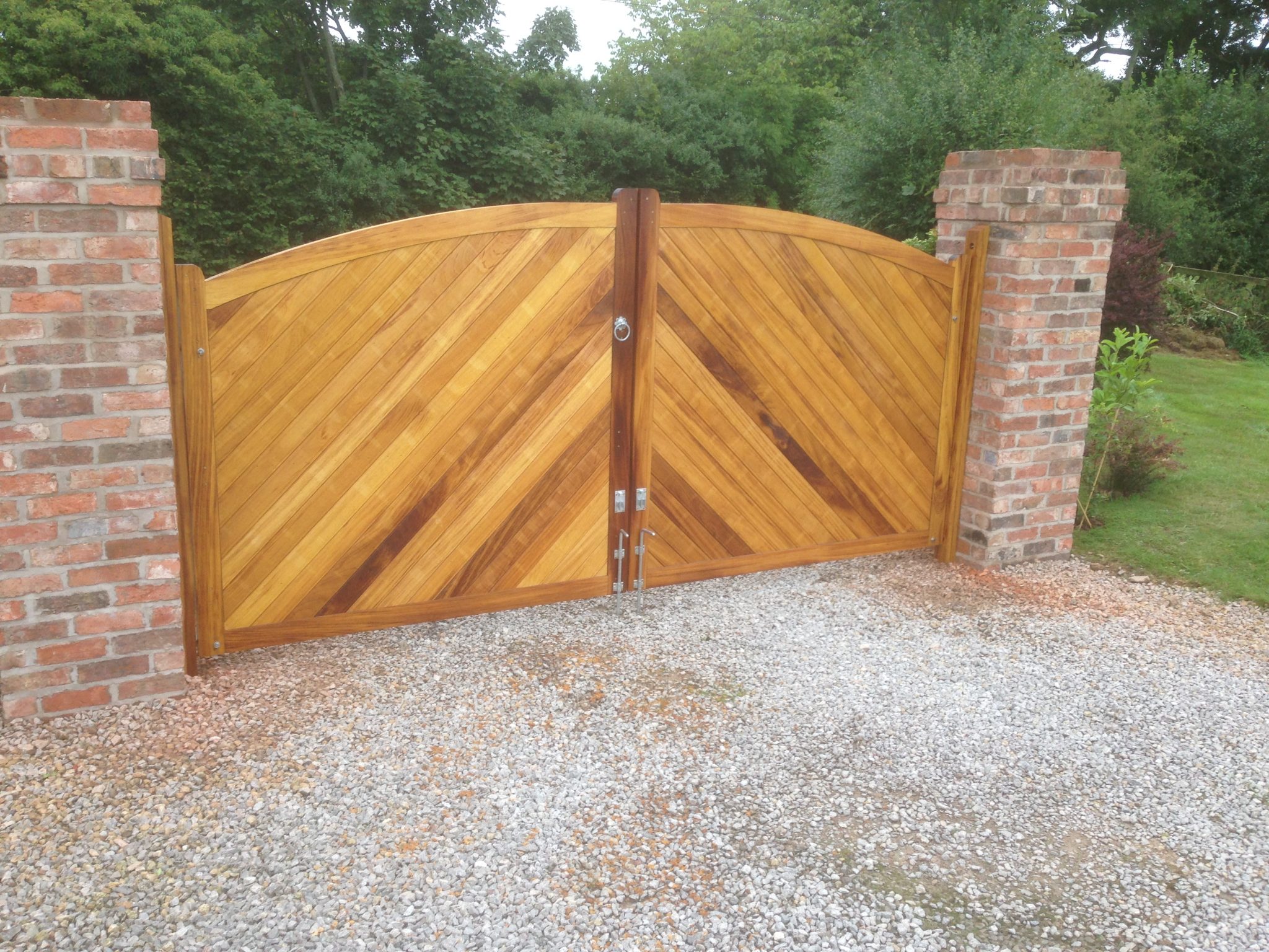 Bow Top Double Driveway Gates made from Iroko. Double sided with herringbone(diagonal) boarding