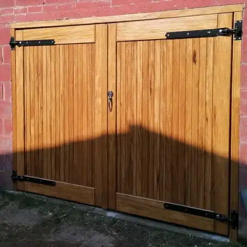 Link to our range of garage doors showing hardwood garage door made from idigbo with black hinges and a lock.